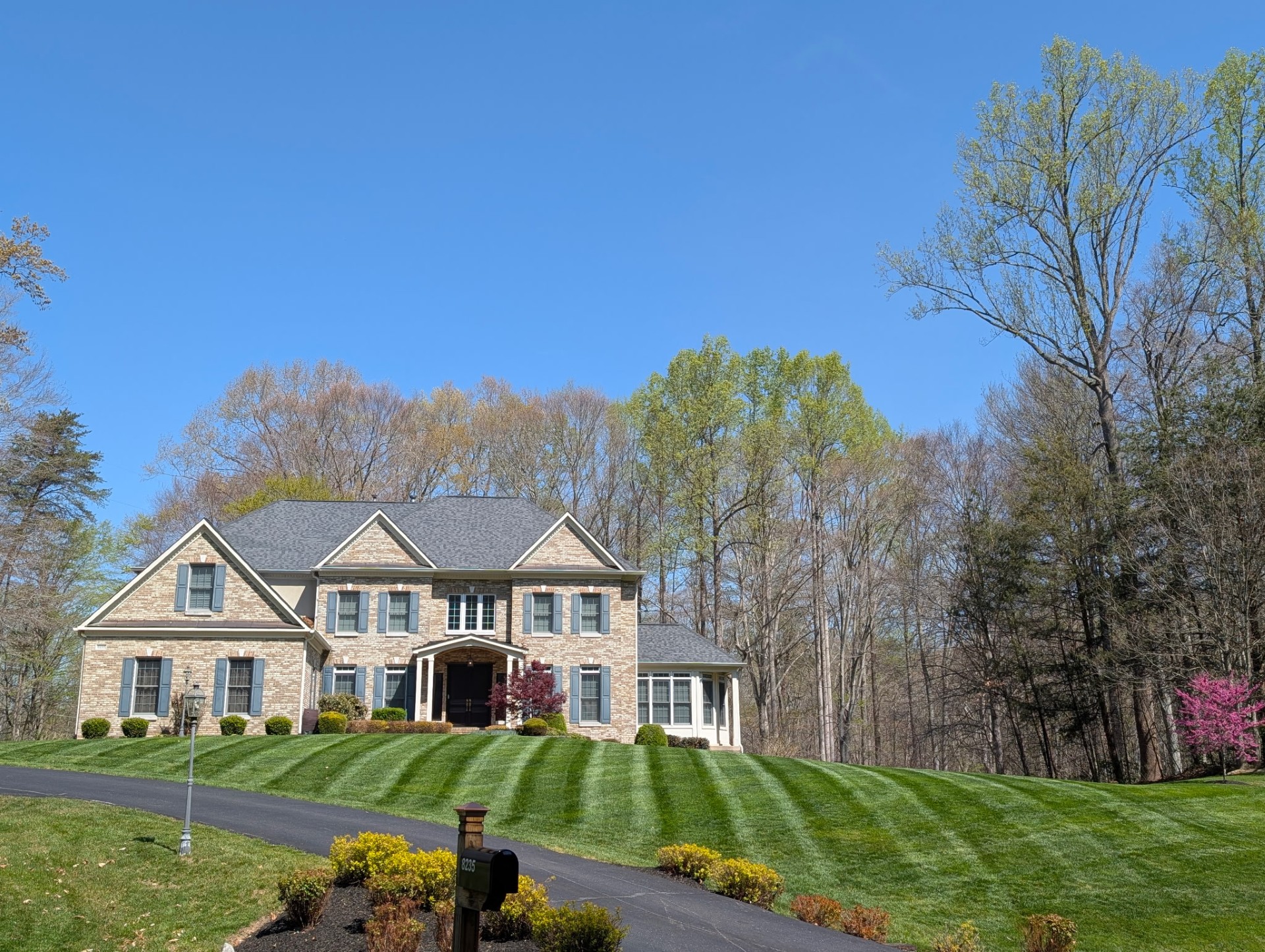 Beautiful large brick home with freshly mowed lawn and tended flower beds